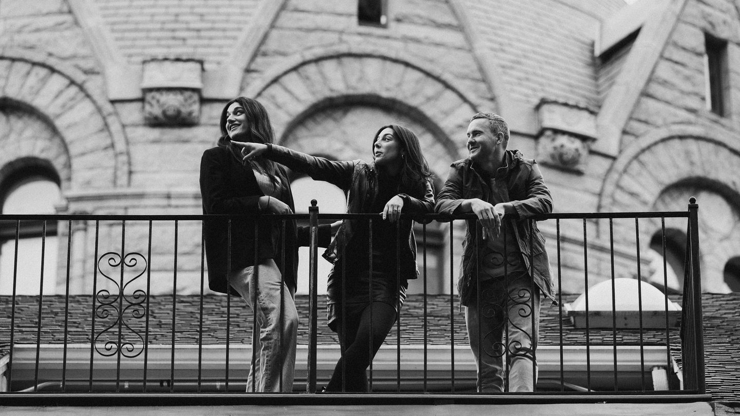 3 people hang out on a patio